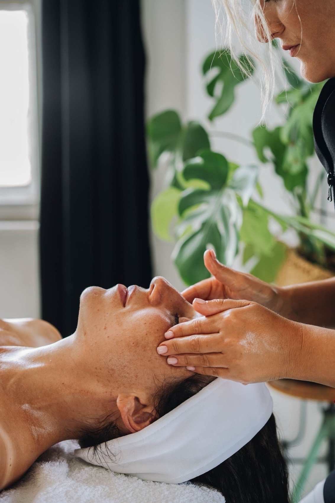 A facial massage session — hands working along the cheek